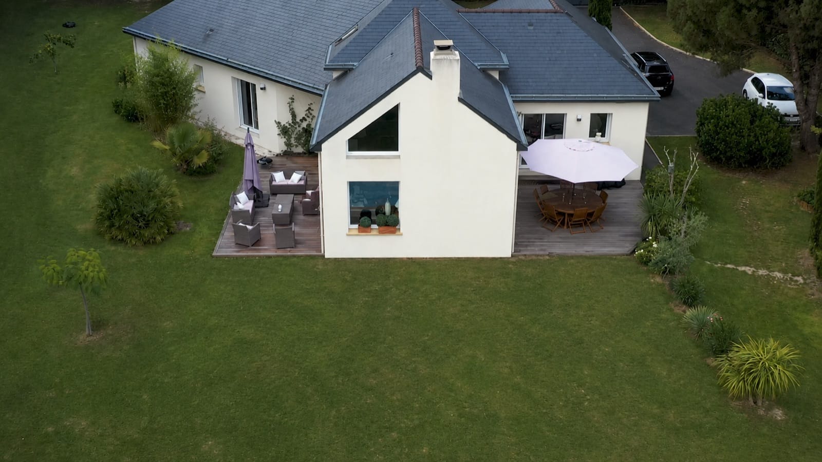 Avant la création : vue aérienne d’une maison et de sa grande pelouse, sans piscine